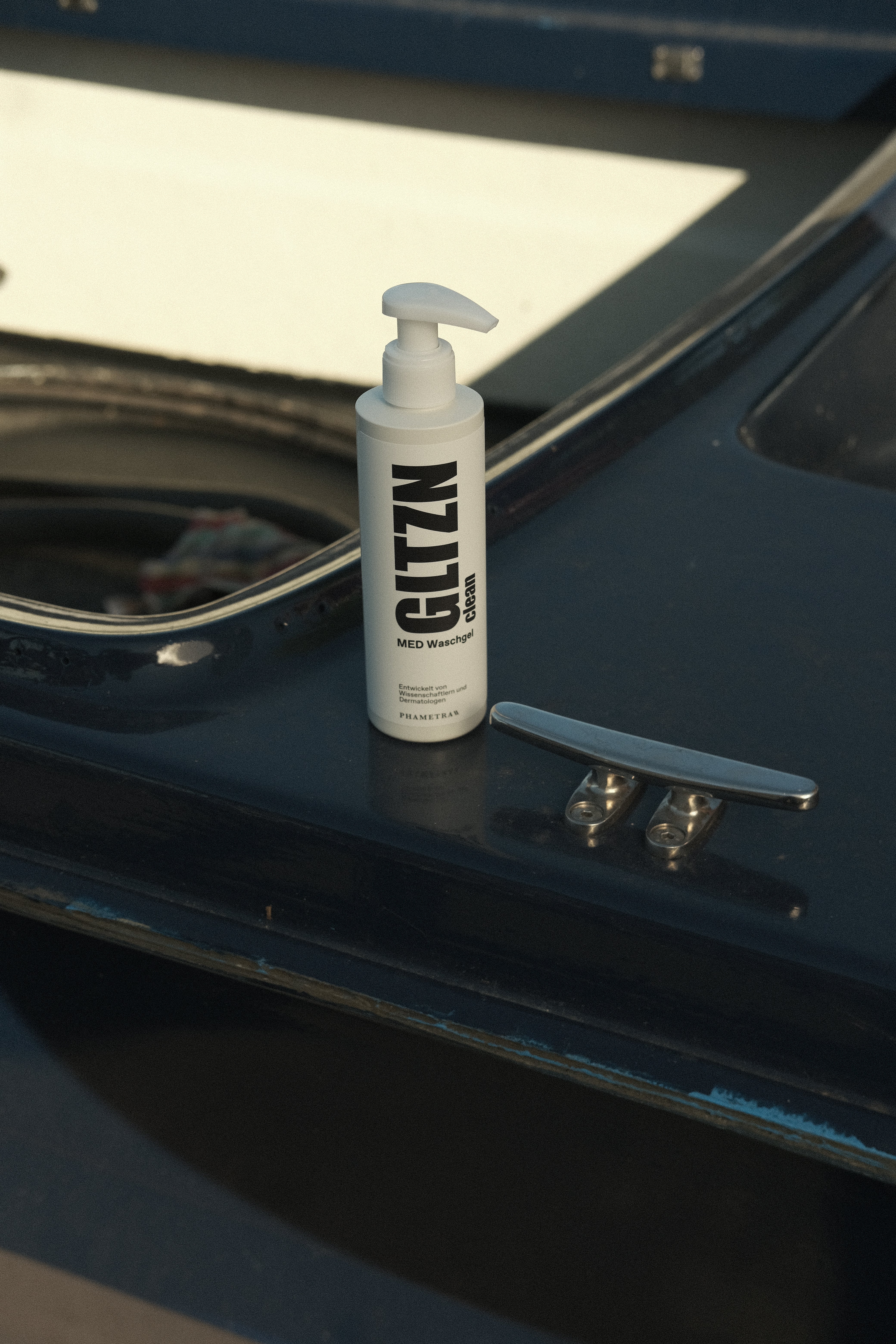 Der weiße Pumpspender mit GLTZN clean MED Waschgel steht auf einem Boot