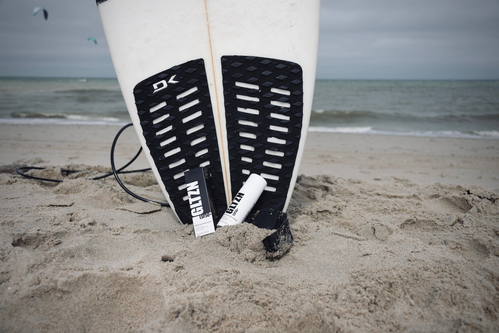 Produktbild GLTZN Sonnencreme am Strand mit Surfboard