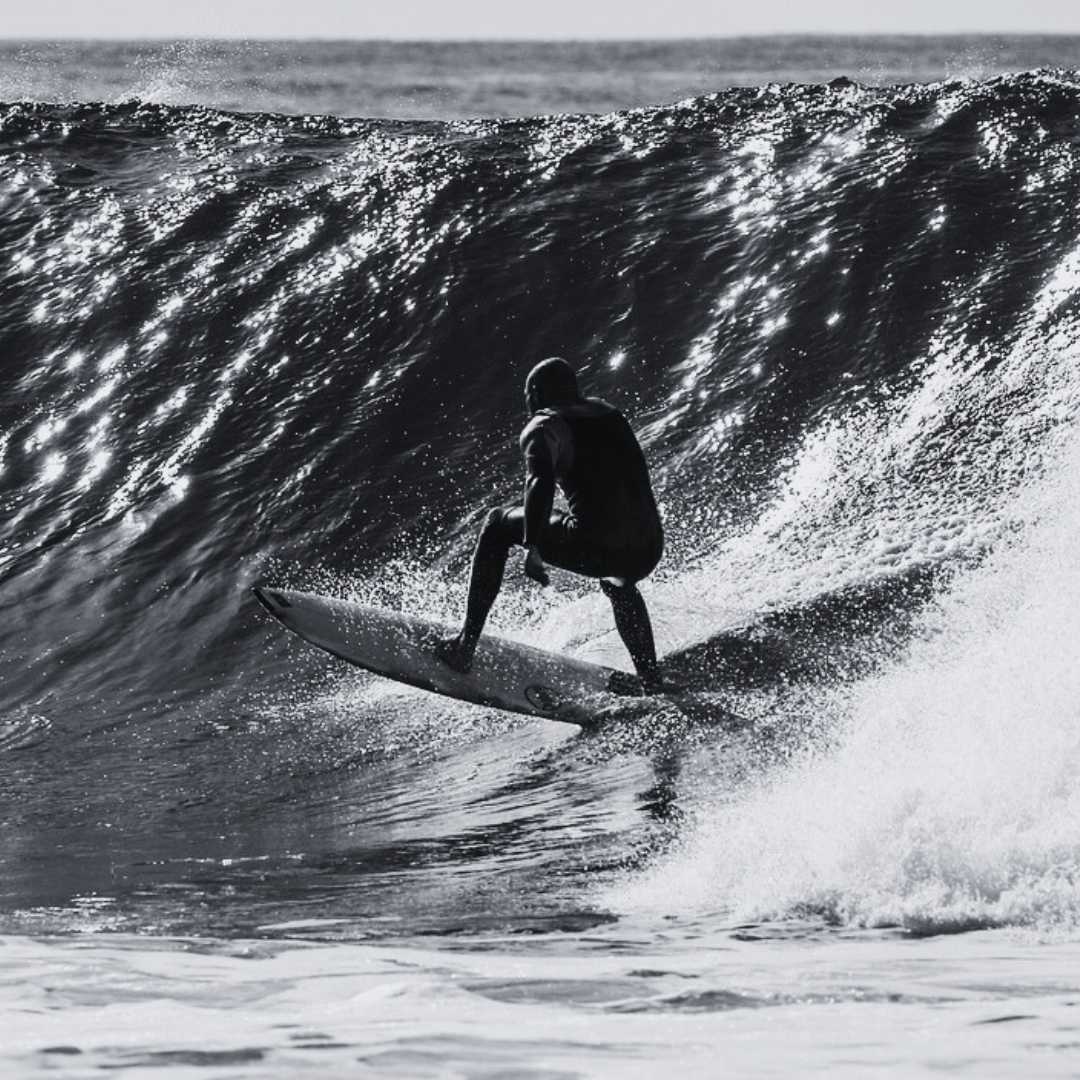 Ein Surfer reitet eine Welle im offenen Meer.